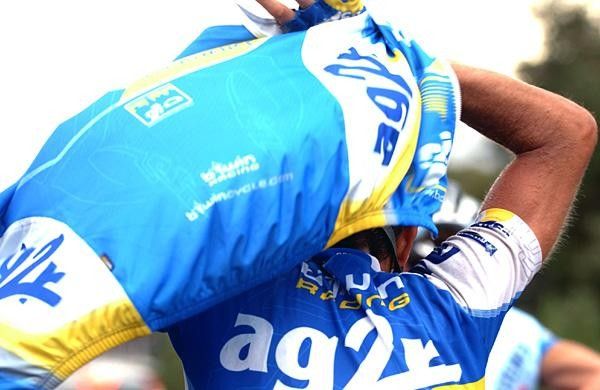 An AG2R rider tries to keep the rain off