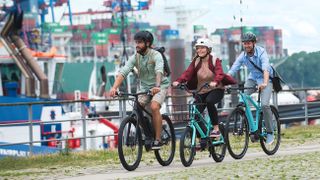 How to buy an electric bike: three riders on e-bikes cycle on a bike path