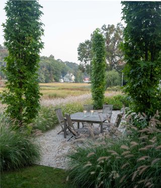 Patio area with gravel flooring and wooden table and chairs