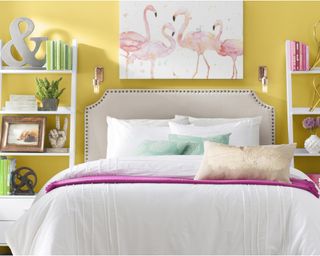 Yellow bedroom with yellow walls and bed with linen headboard and white and pink bedding