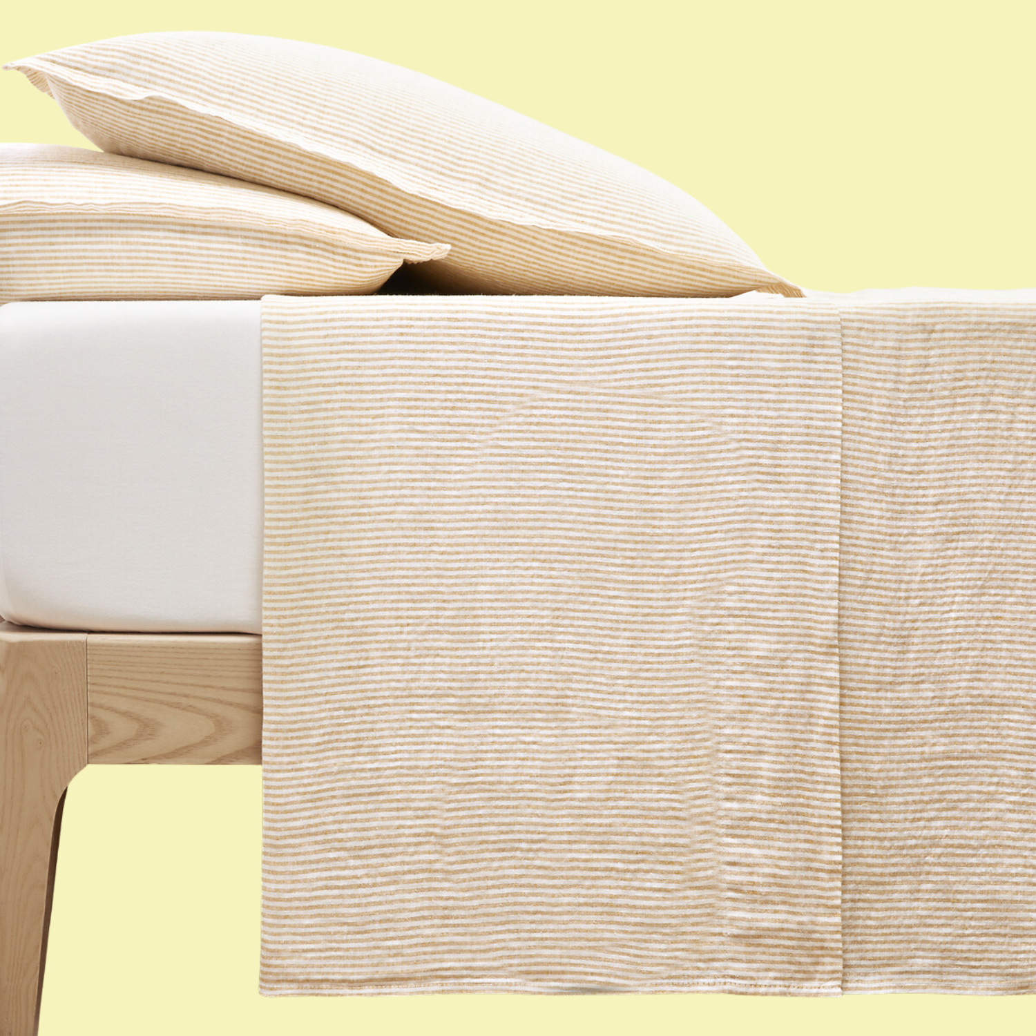 A bed with a striped sheet and pillow set