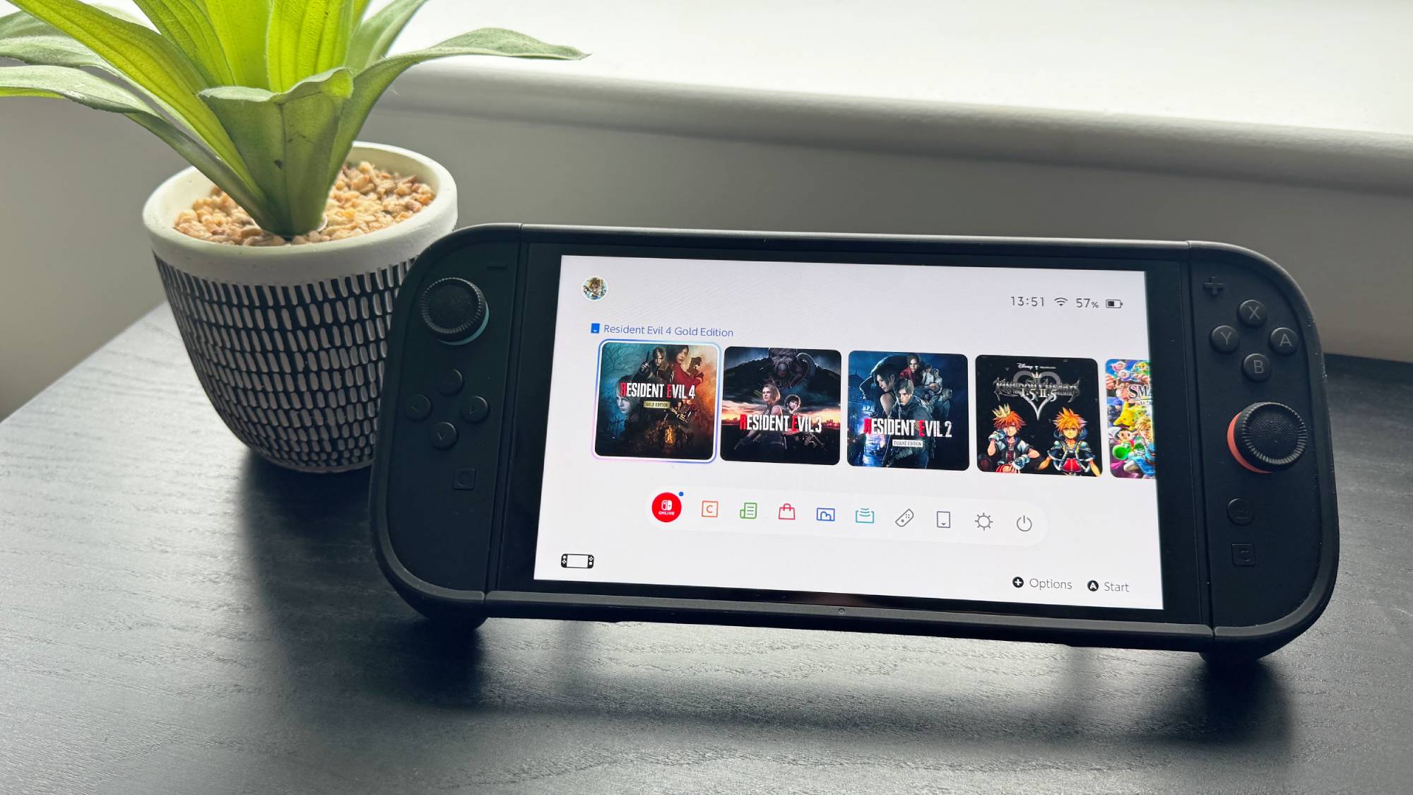 Nintendo Switch 2 console on a table displaying tiles for three Resident Evil games
