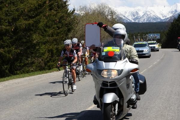 The lead group gets a time gap update from the officials.