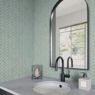 A green herringbone tile layout in a bathroom
