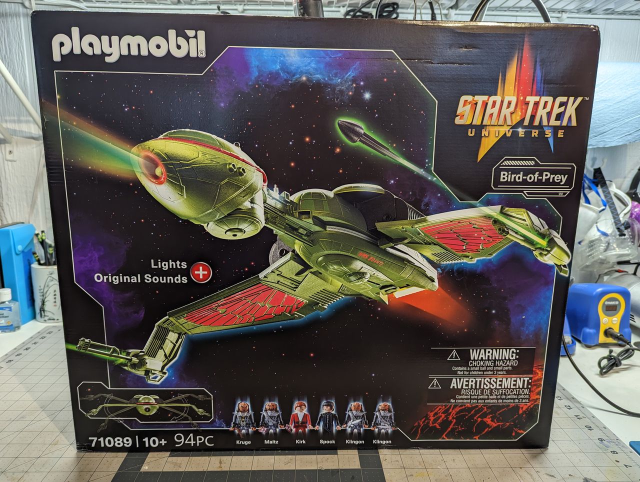 a child assembles a klingon bird of prey on a workbench