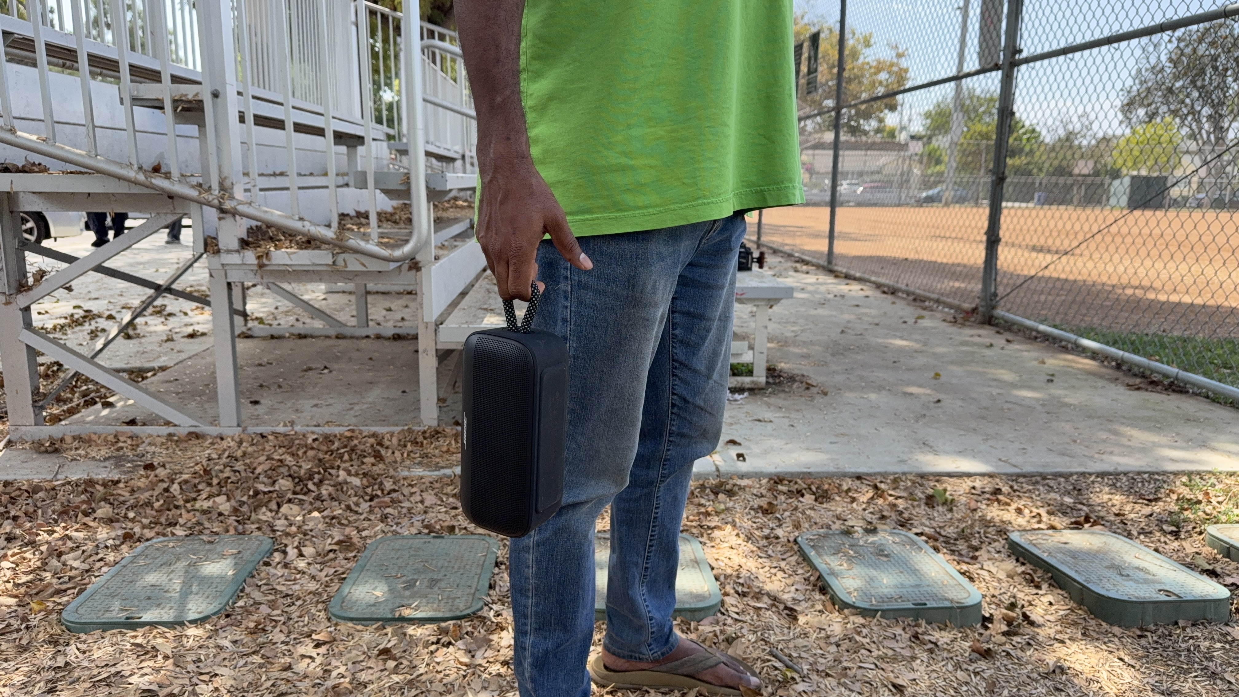 Bose SoundLink Plus being held by the rugged nylon carry loop