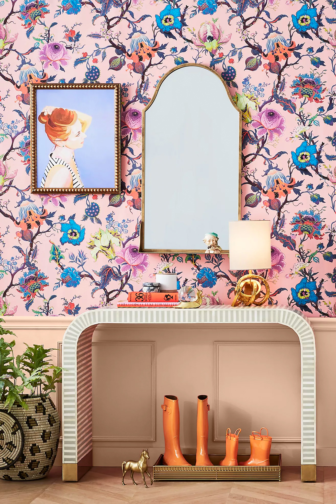 Pink and blue feature wallpaper in entryway with white console and mirror