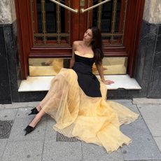 Bettina Looney wearing a strapless black-and-yellow wedding guest dress