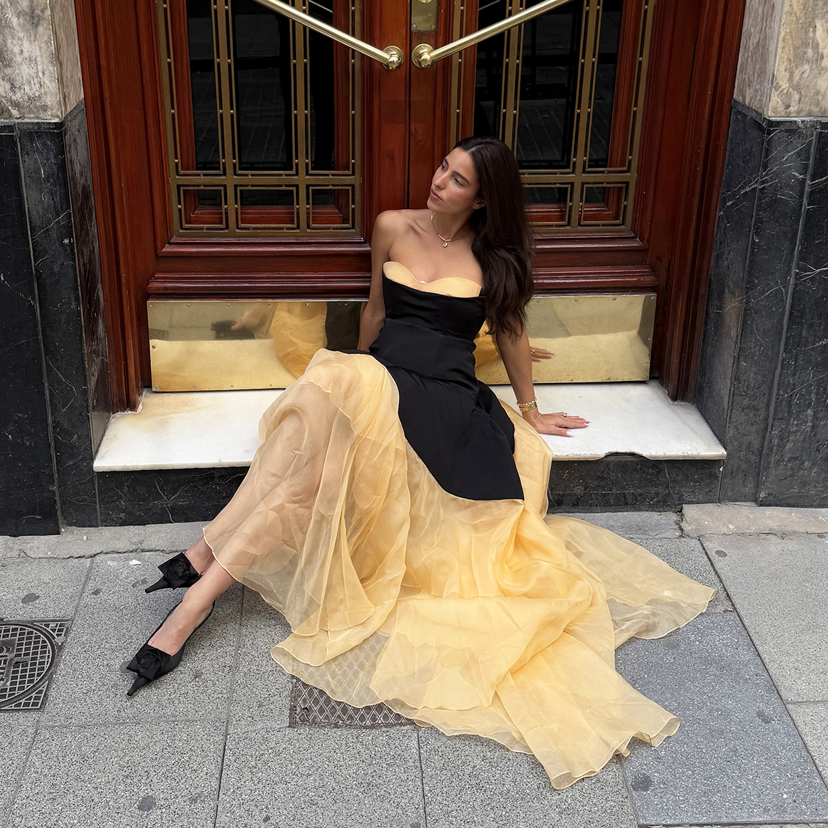Bettina Looney wearing a strapless black-and-yellow wedding guest dress