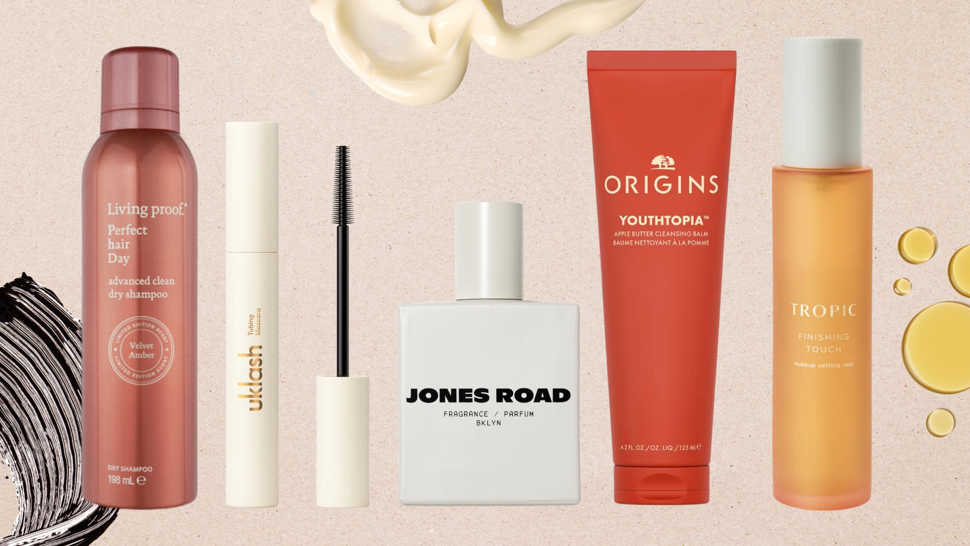 Collage of the best new beauty launches (L-R) Living Proof Perfect Hair Day Velvet Amber Dry Shampoo, UKLASH Tubing Mascara, Jones Road BKYLN Fragrance, Origins Youthtopia Apple Butter Cleansing Balm and Tropic Setting Spray, on a neutral background with mascara, cream and oil swatches