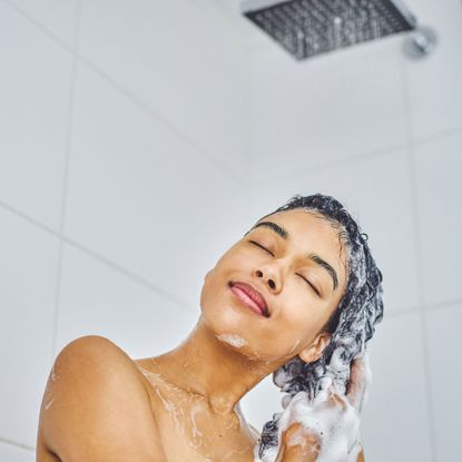 a model washing her hair with a clarifying shampoo
