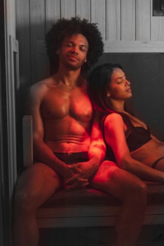 man and woman sitting in a grey wolfe sauna