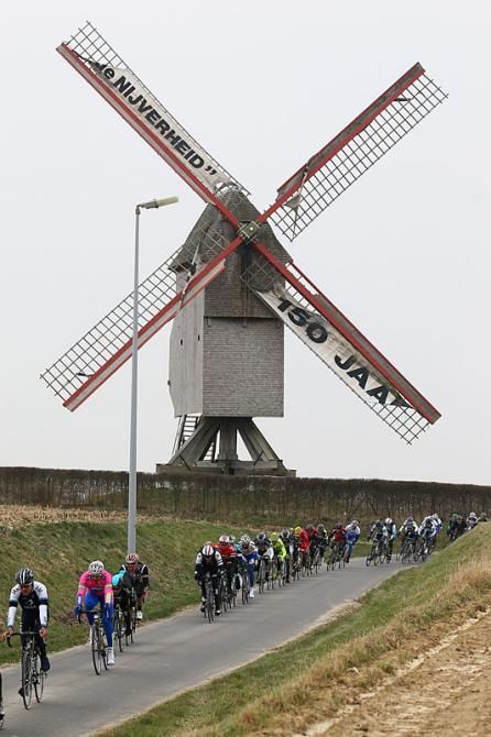 The peloton passes a windmill