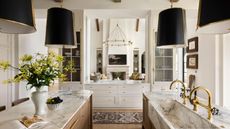 A double island kitchen with a hatch into the living room