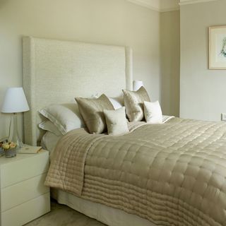 luxurious bedroom with neutral walls and pillows