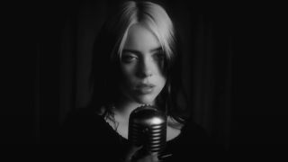 Billie Eilish singing in front of a microphone in No Time To Die.