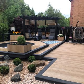 Outdoor decking space with loungers, the decking has steps that are enhanced with black edging