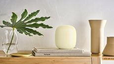 Google Nest WiFi Pro on shelf between vase and candleholders