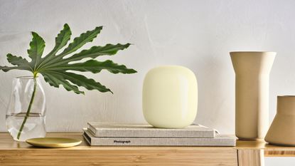 Google Nest WiFi Pro on shelf between vase and candleholders