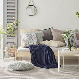 room with sofa cushions and navy blue blanket