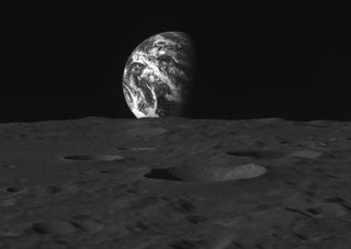 The Earth rising over the moon's horizon