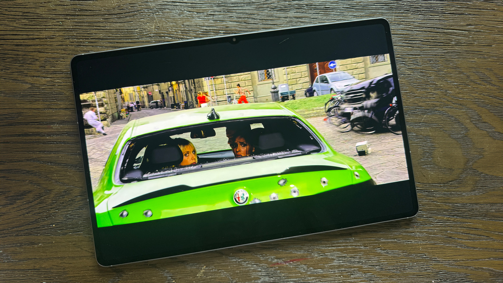 Samsung Galaxy Tab S11 Ultra tablet on wooden table, on screen is back of green car