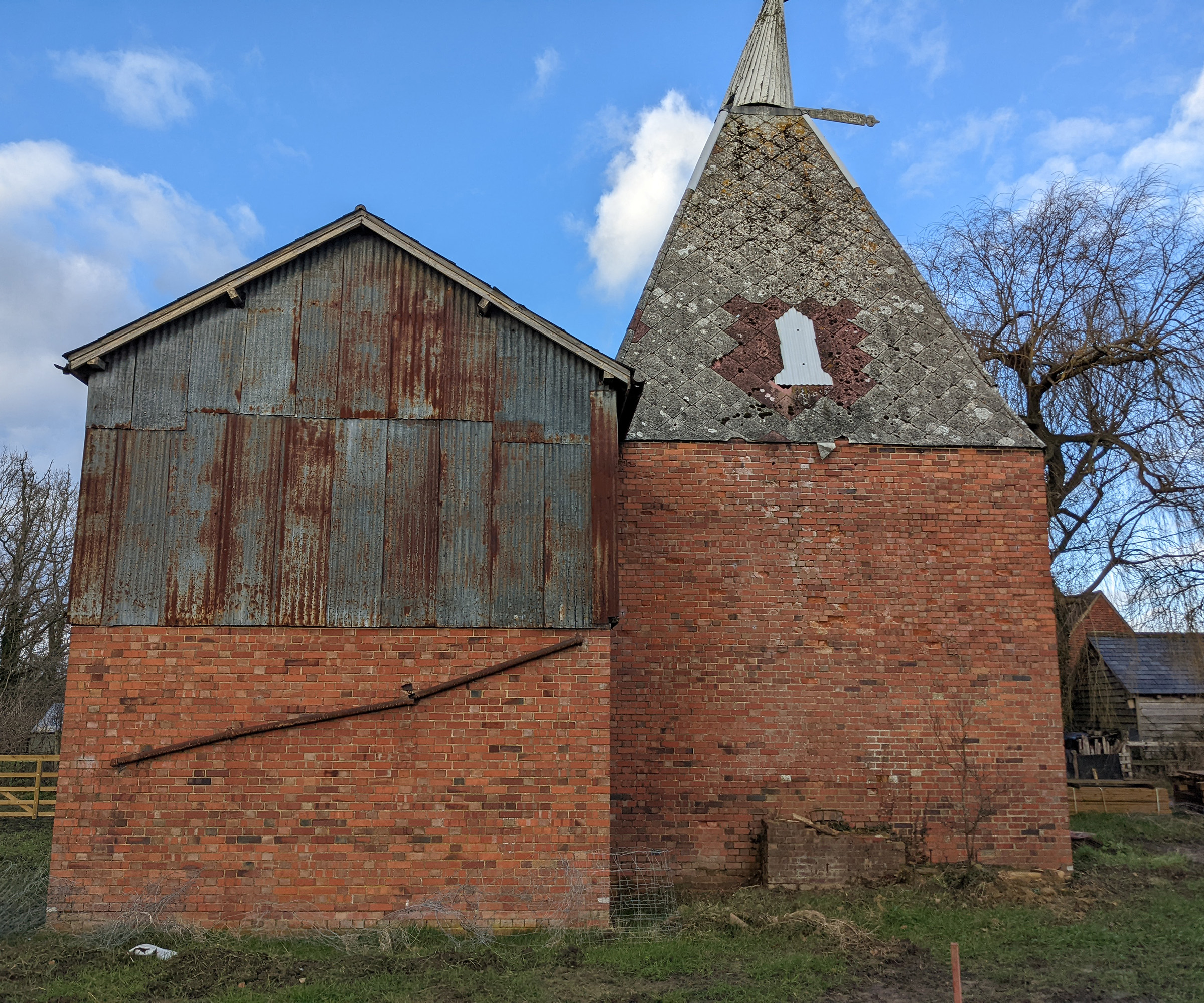 Exterior of a dilapidated oast house before a renovation