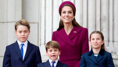 Prince George, Prince Louis, Catherine, Princess of Wales and Princess Charlotte watch a flypast from the balcony of Buckingham Palace