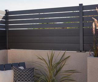 Composite fence panel with horizontal slats on a garden wall GoodHome Neva Fence panel (W)1.79m (H)0.44m