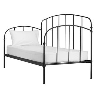 Bed made from steel rods with with mattress and white pillow