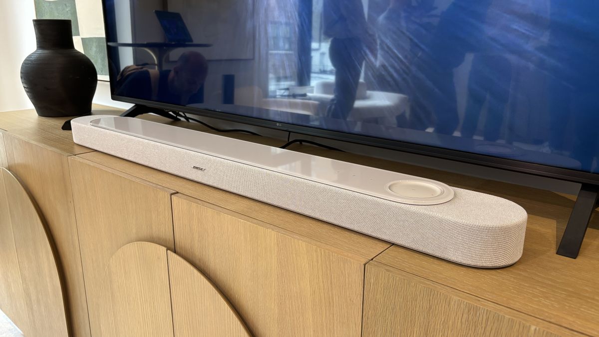 Bose Lifestyle Ultra Dolby Atmos soundbar in white smoke in front of a 75-inch TV