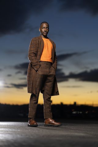 Ncuti Gatwa in his brown tweed suit costume as The Doctor.