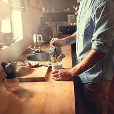 Someone making coffee on a kitchen counter