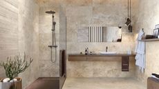 neutral bathroom with natural stone floor and wall tile and walk-in shower