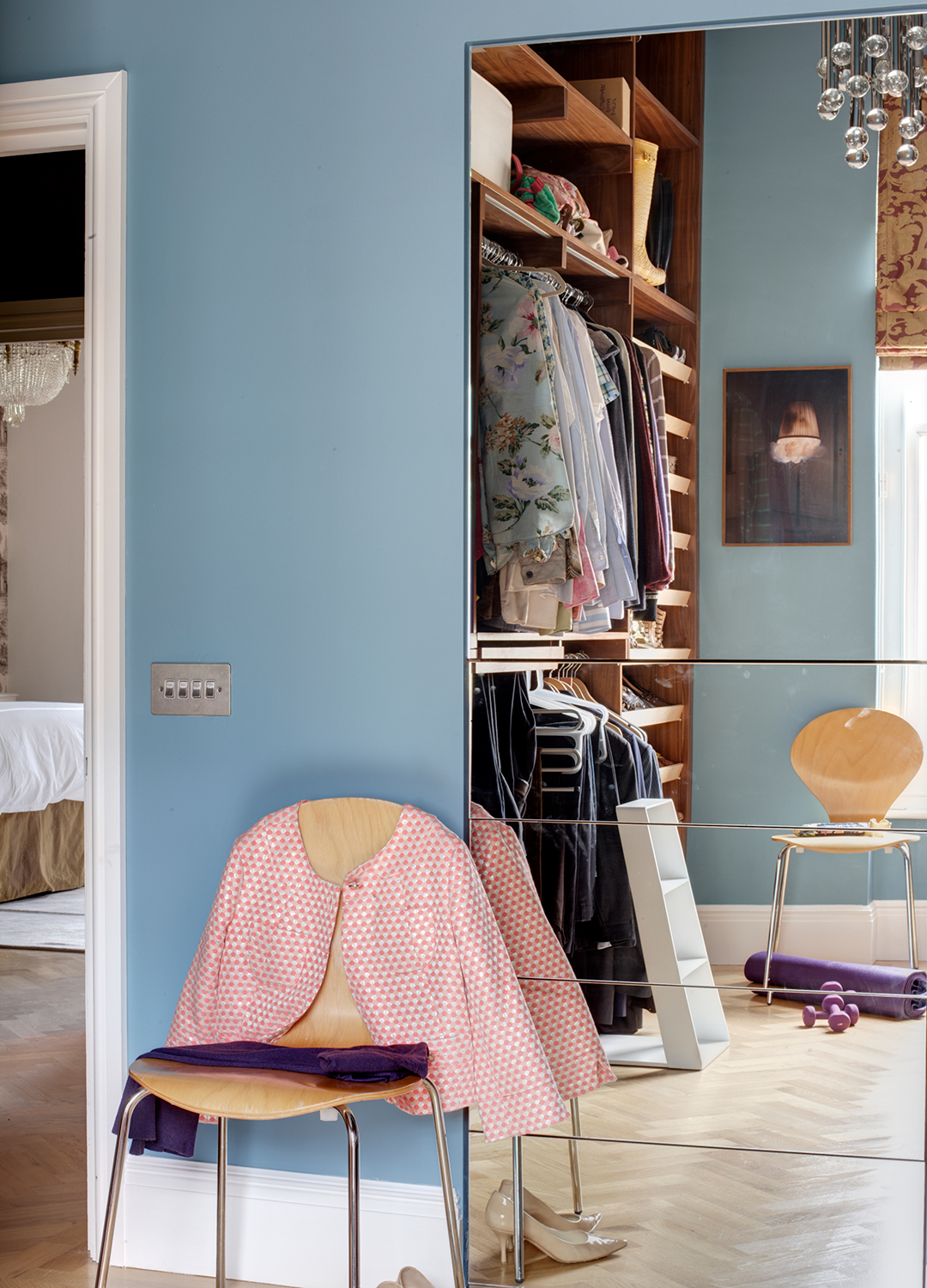 Blue bedroom with an open wardrobe of hanging compartments and shelving to test the wardrobe editing method
