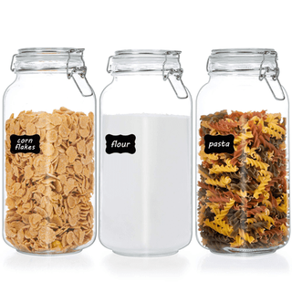 Three large glass kilner jars with kinge clip lids and black stickers on the front. 