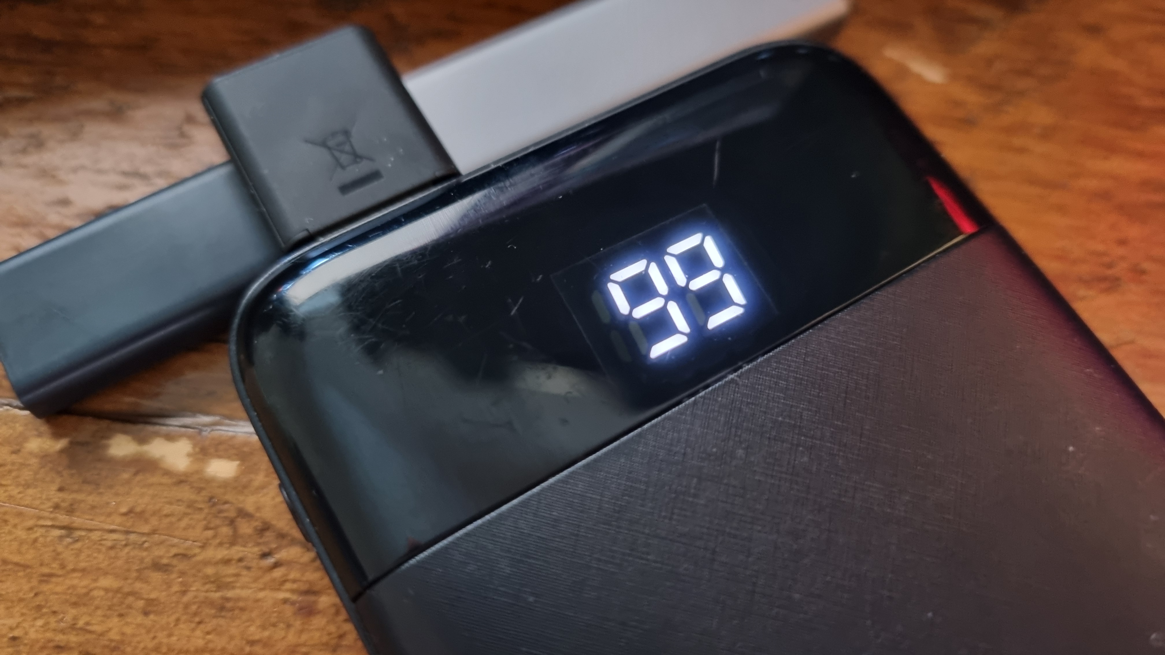 A Charmast portable power bank on a wooden desk