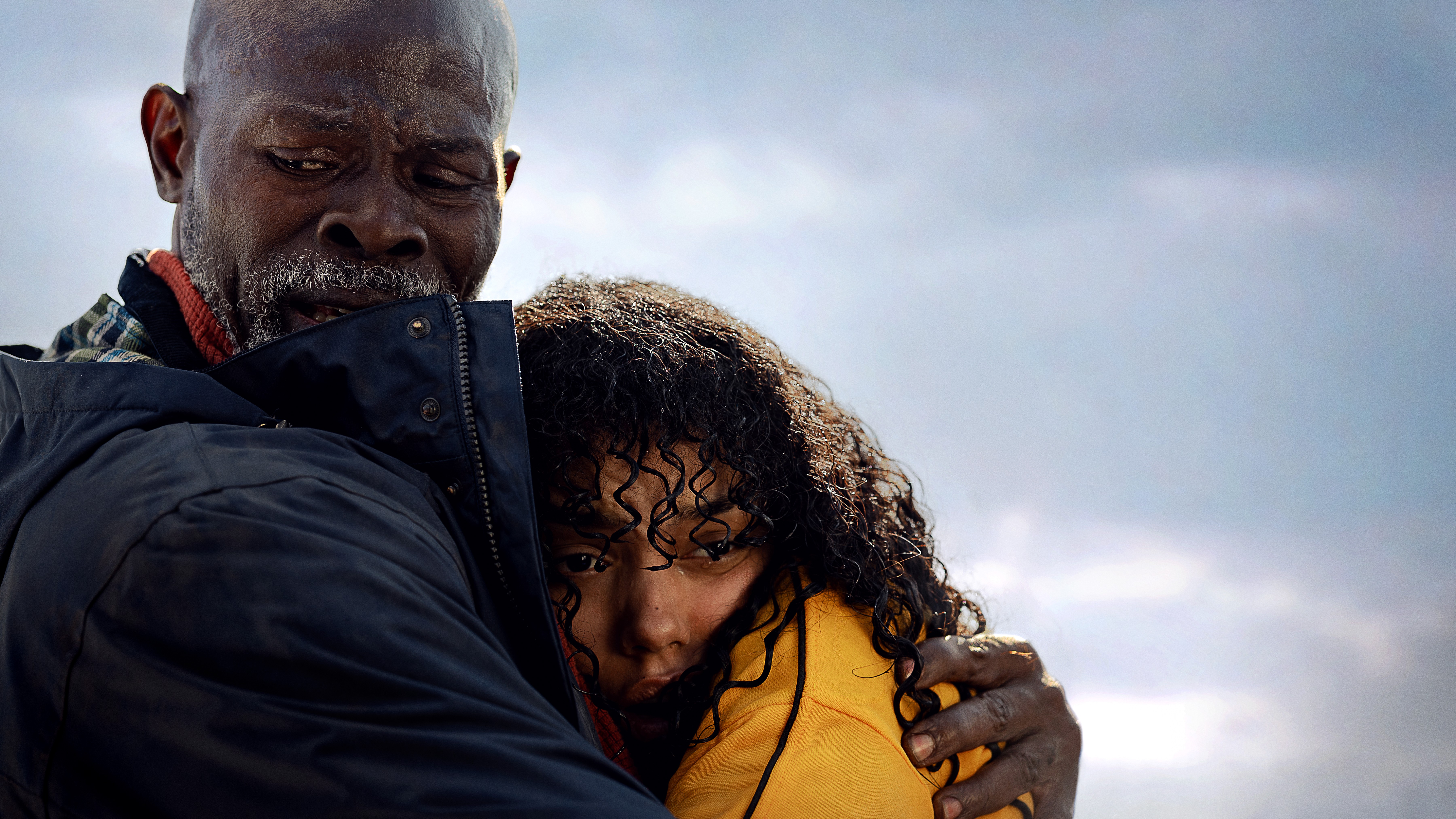 Dr. Dale Edwards (Djimon Hounsou) hugs Dakota (Whitney Peak) in a scene from Netflix shark survival thriller movie "Thrash"