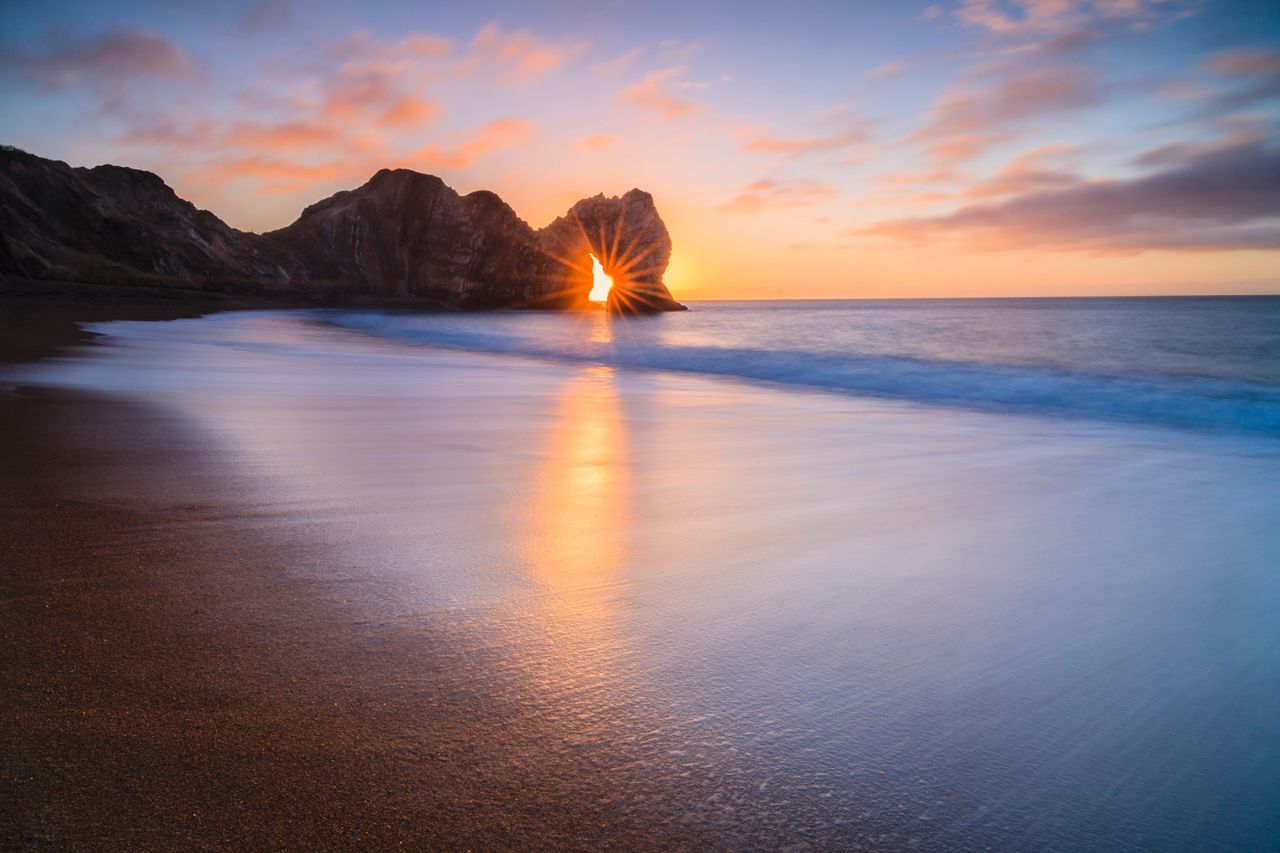 PICTURE OF THE DAY: The sun rising through the arch at Durdle Door, Dorset.