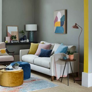 living room with grey wall and sofa with cushions and painting frame on wall
