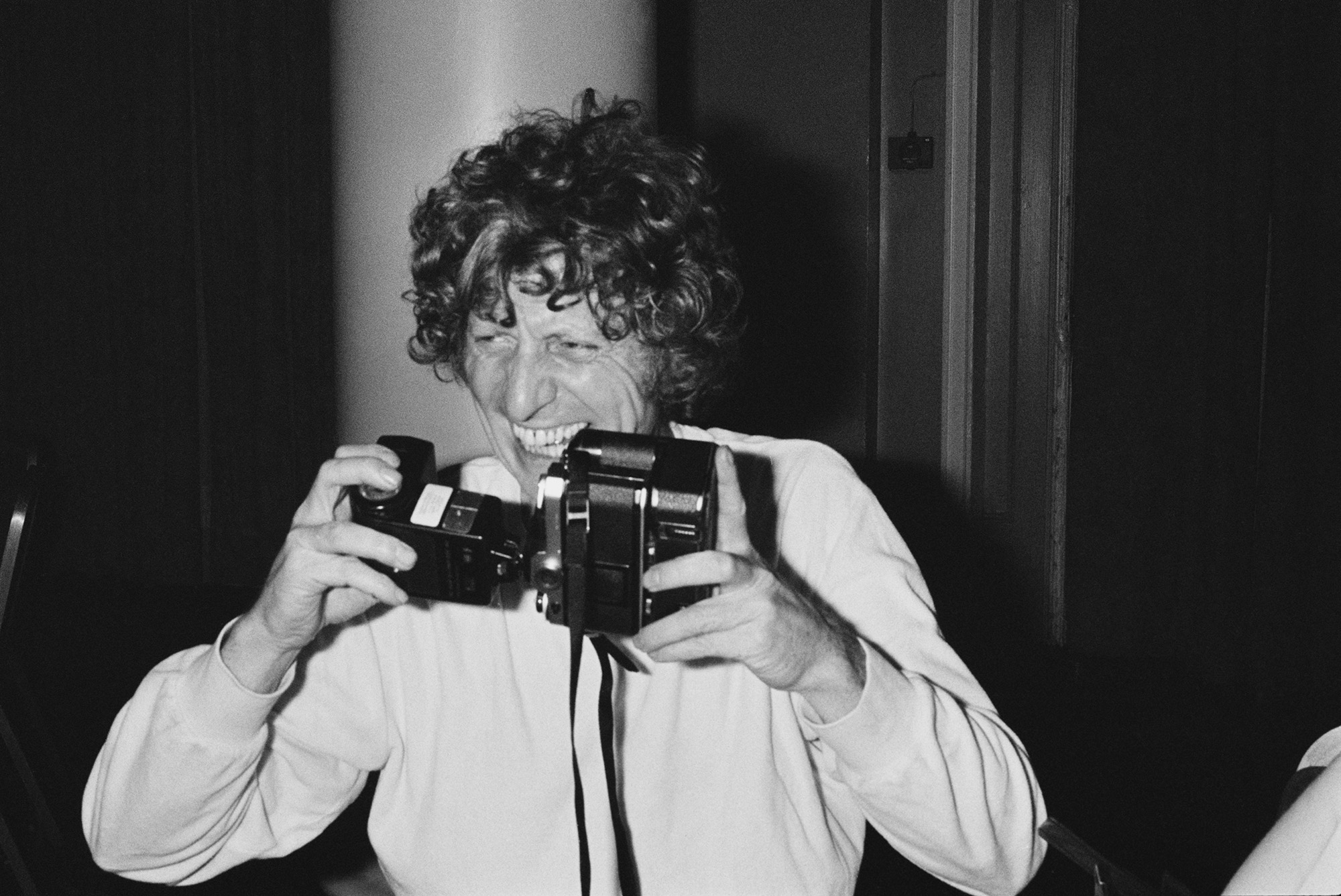 English actor Tom Baker holding a camera, UK, 4th September 1980.