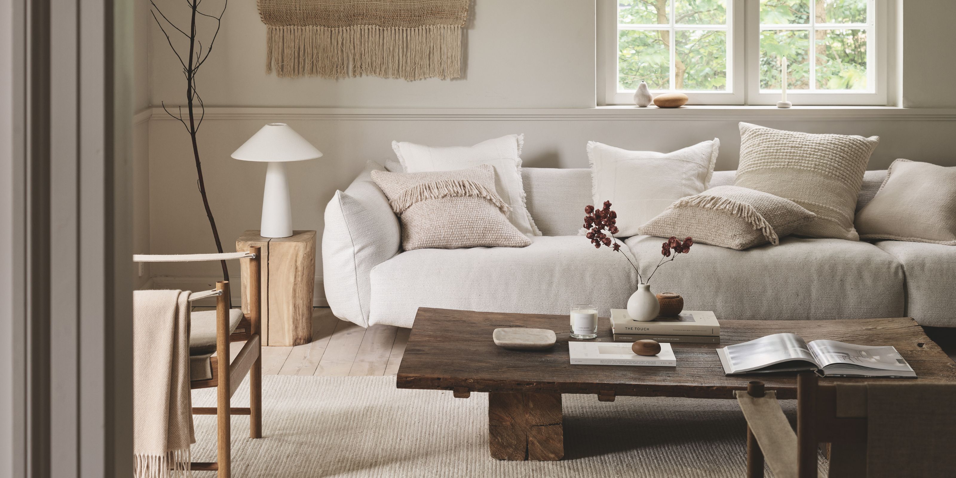 A beige living room with dark wood accents, part of The White Company's new autumn collection