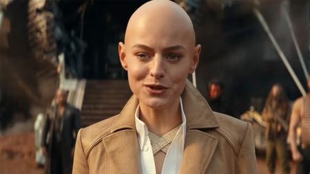 Emma Corrin in a button up, blazer and with a bald head in Deadpool & Wolverine.