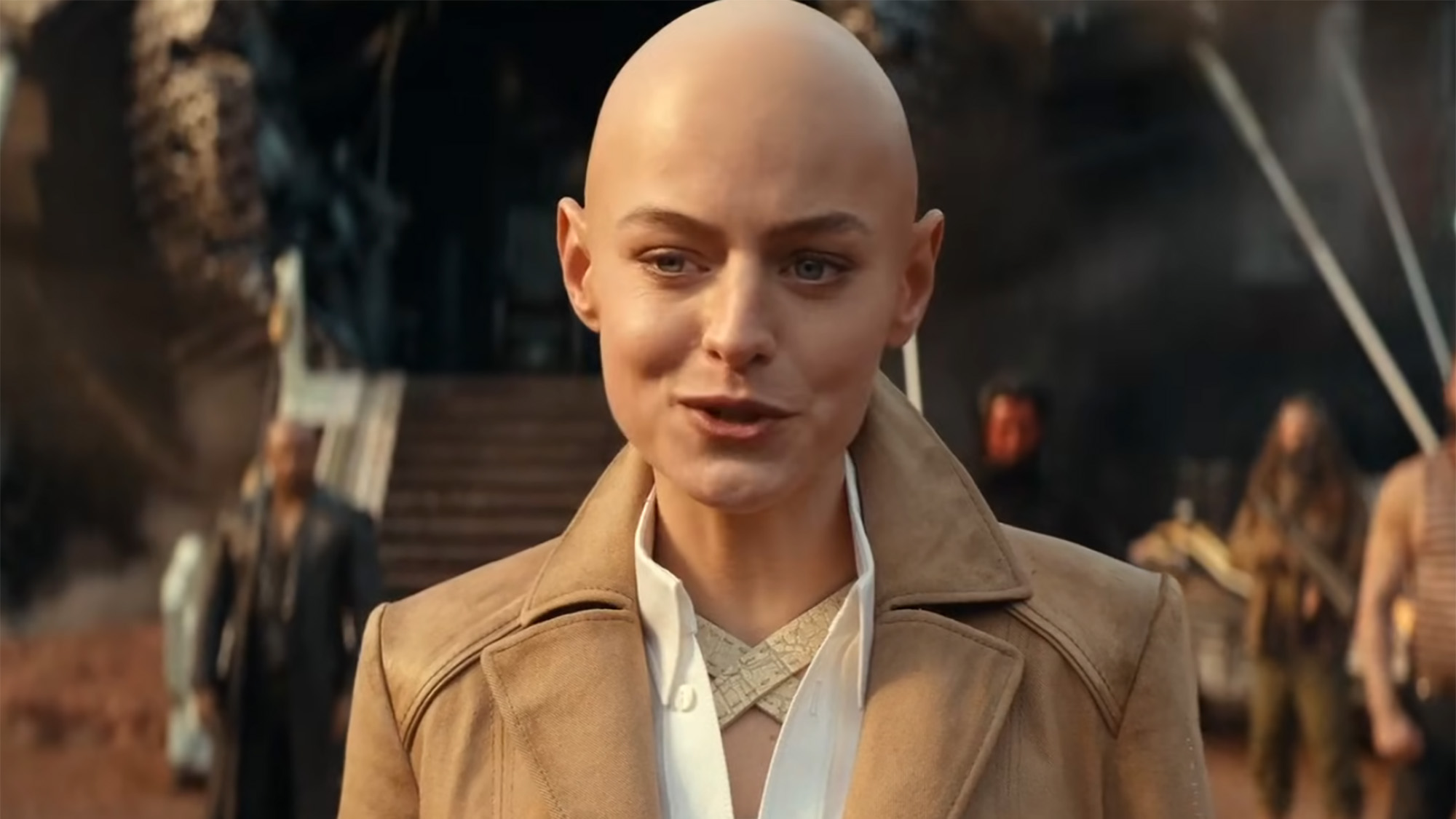 Emma Corrin in a button up, blazer and with a bald head in Deadpool &amp; Wolverine.