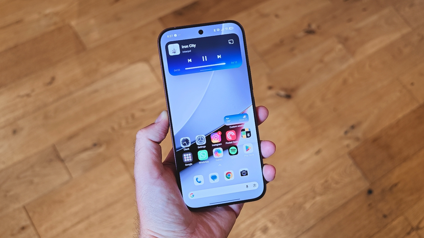 The Poco F9 Ultra being held in the hand and resting on a table