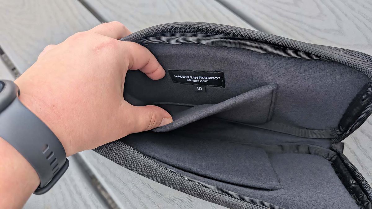 A hand holding the inner pocket of the Waterfield ROG Ally X Magnetic Case open.