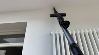 The Miele Duoflex HX1 cleaning a ceiling crevice.