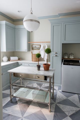 blue laundry room with center island folding table