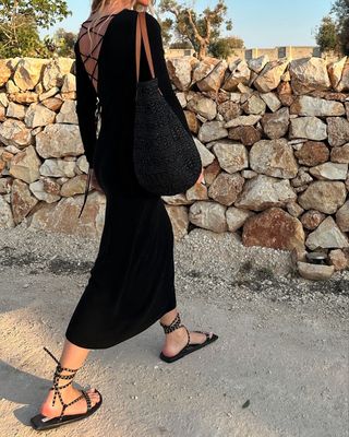 @_jeanettemadsen_ wearing strappy sandals and a black dress