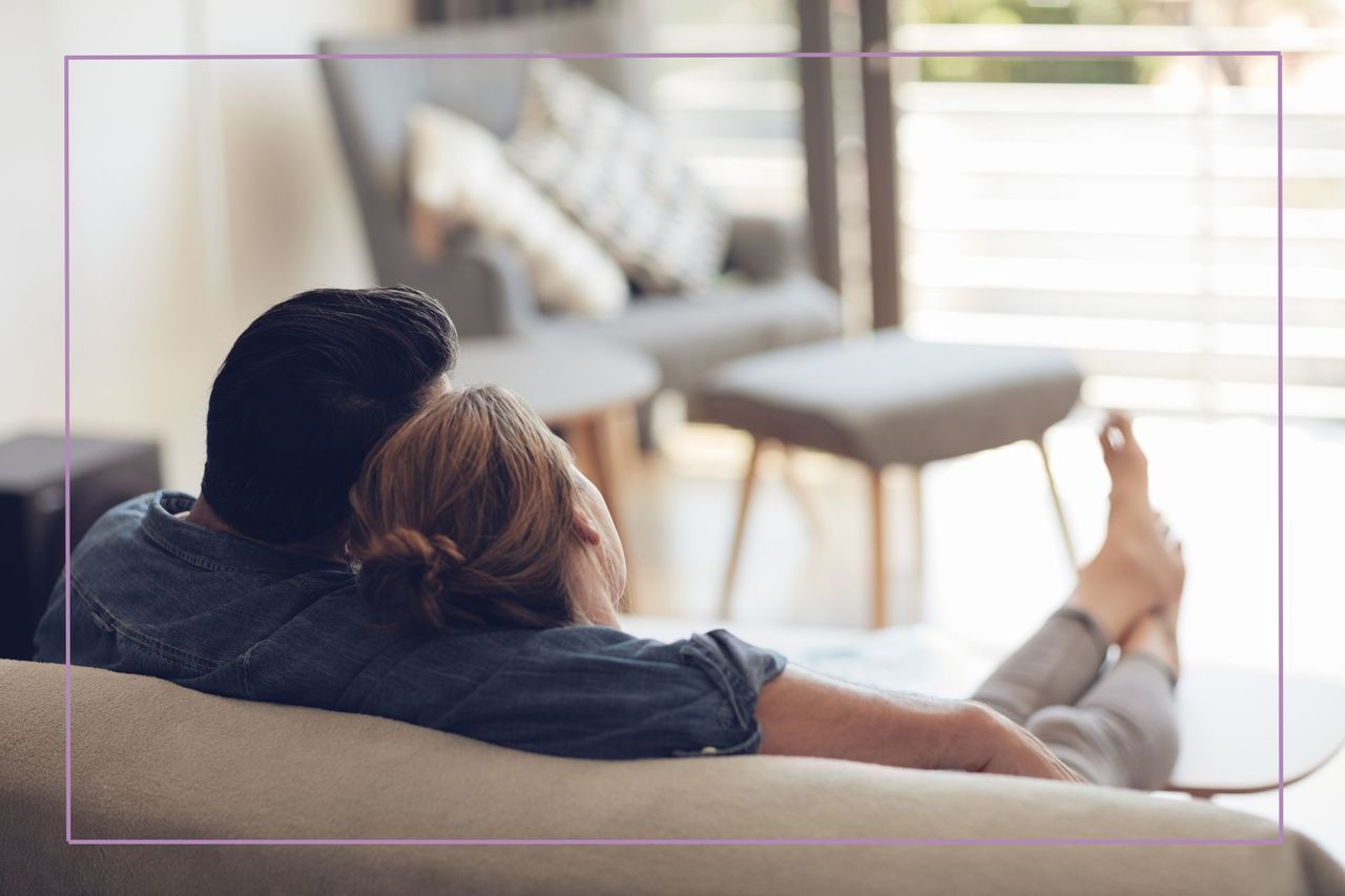 High angle shot of an unrecognizable couple relaxing on their couch at home